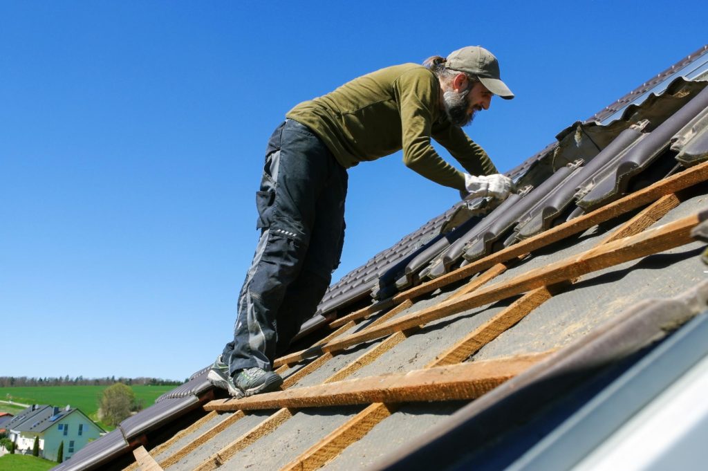 man installing shingle in the roof