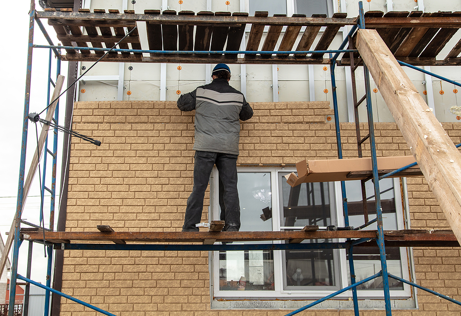 worker installing bricks in the wall